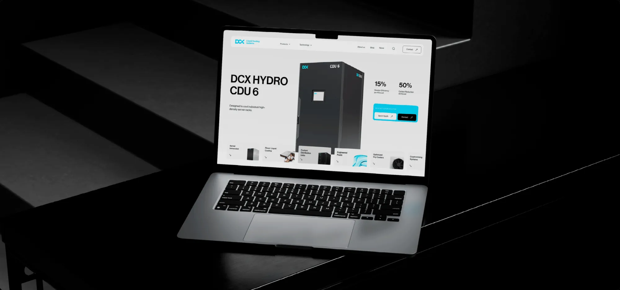 Projekt strony DCX na ekranie laptopa w ciemnym wnętrzu.