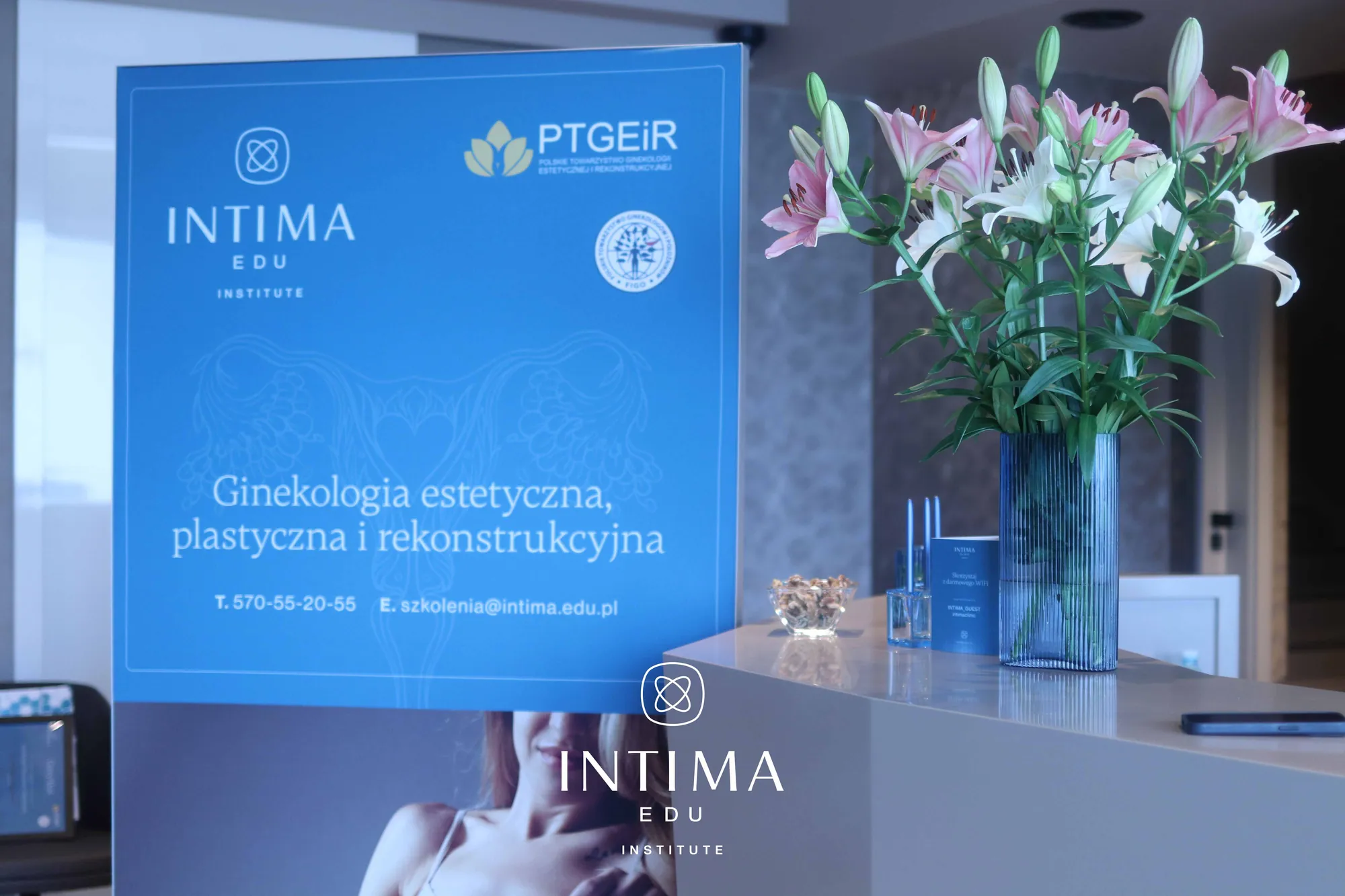Rollup Intima Edu w klinice podczas szkolenia, obok bukiet lilii