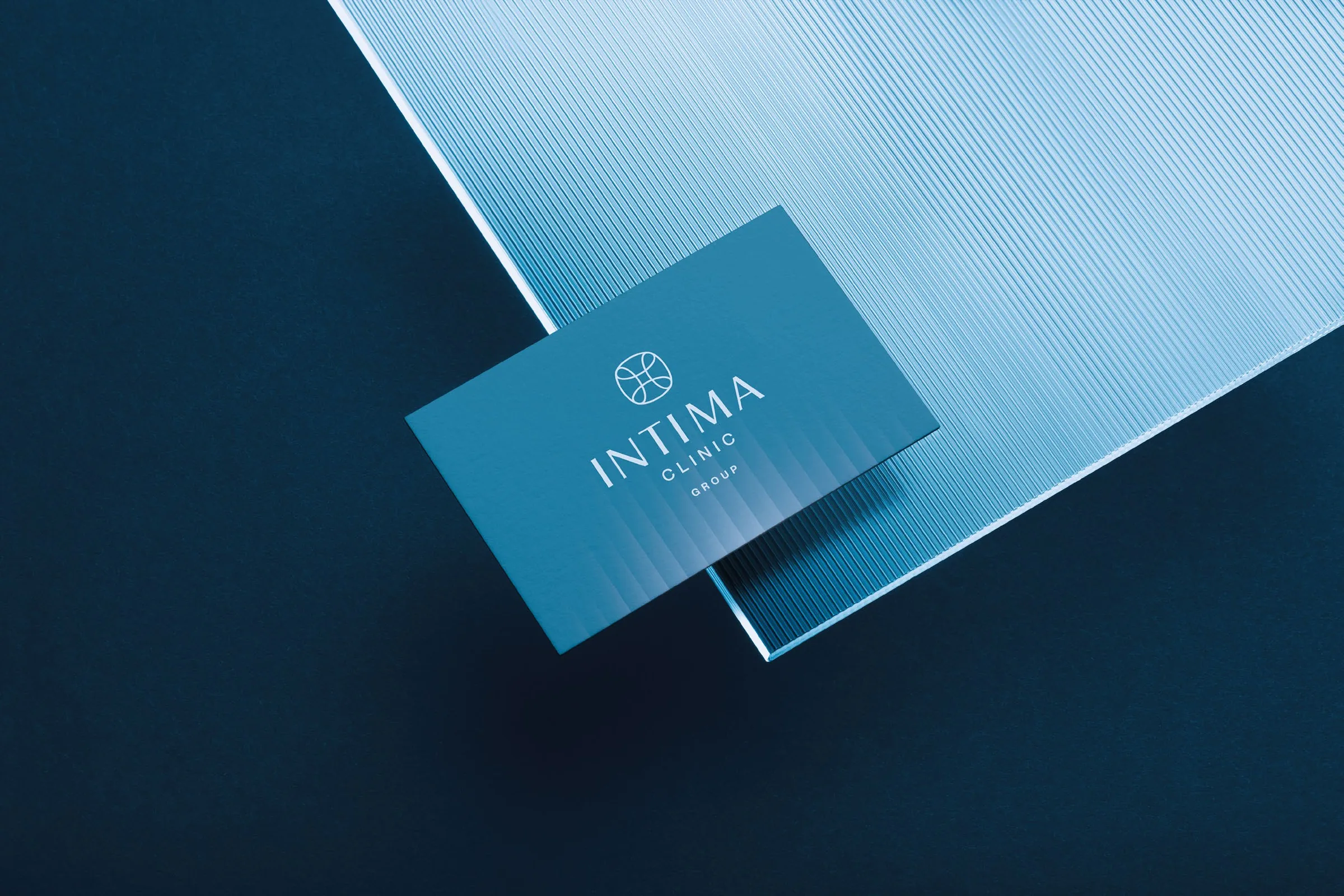 Wizytówka Intima Clinic Group na ryflowanym szkle