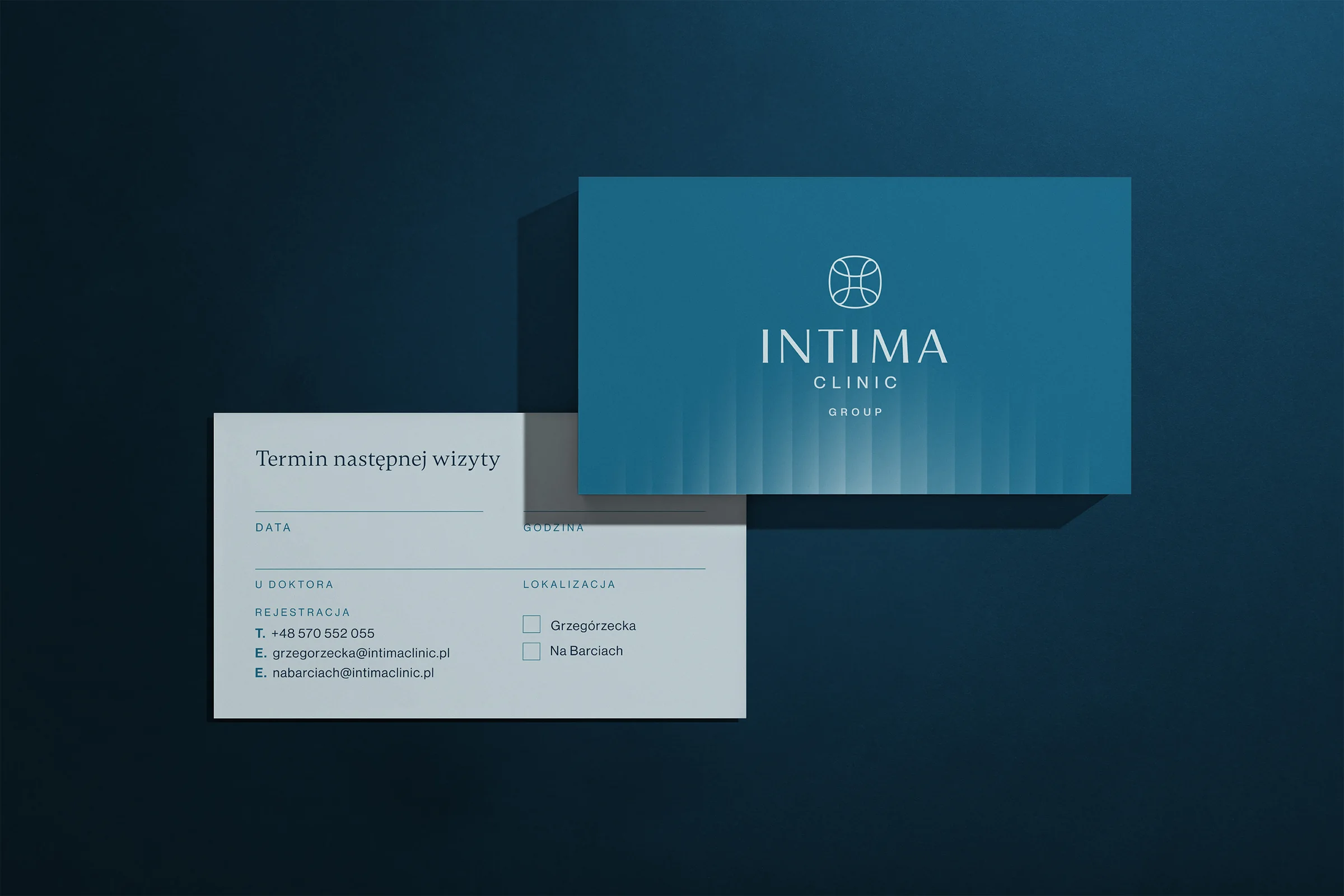 Wizytówka Intima Clinic Group i karta z terminem następnej wizyty na granatowym tle