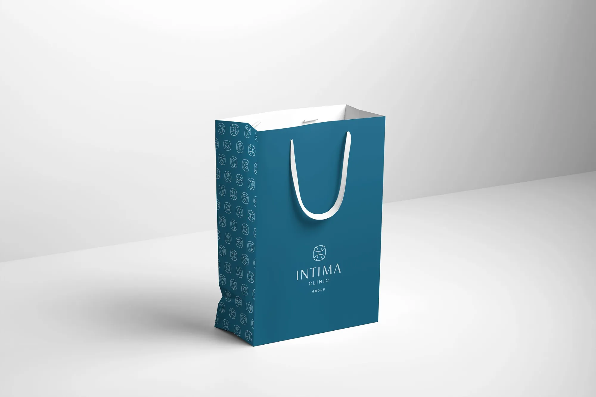 Papierowa torba Intima Clinic i wzór ze znakami na jej boku
