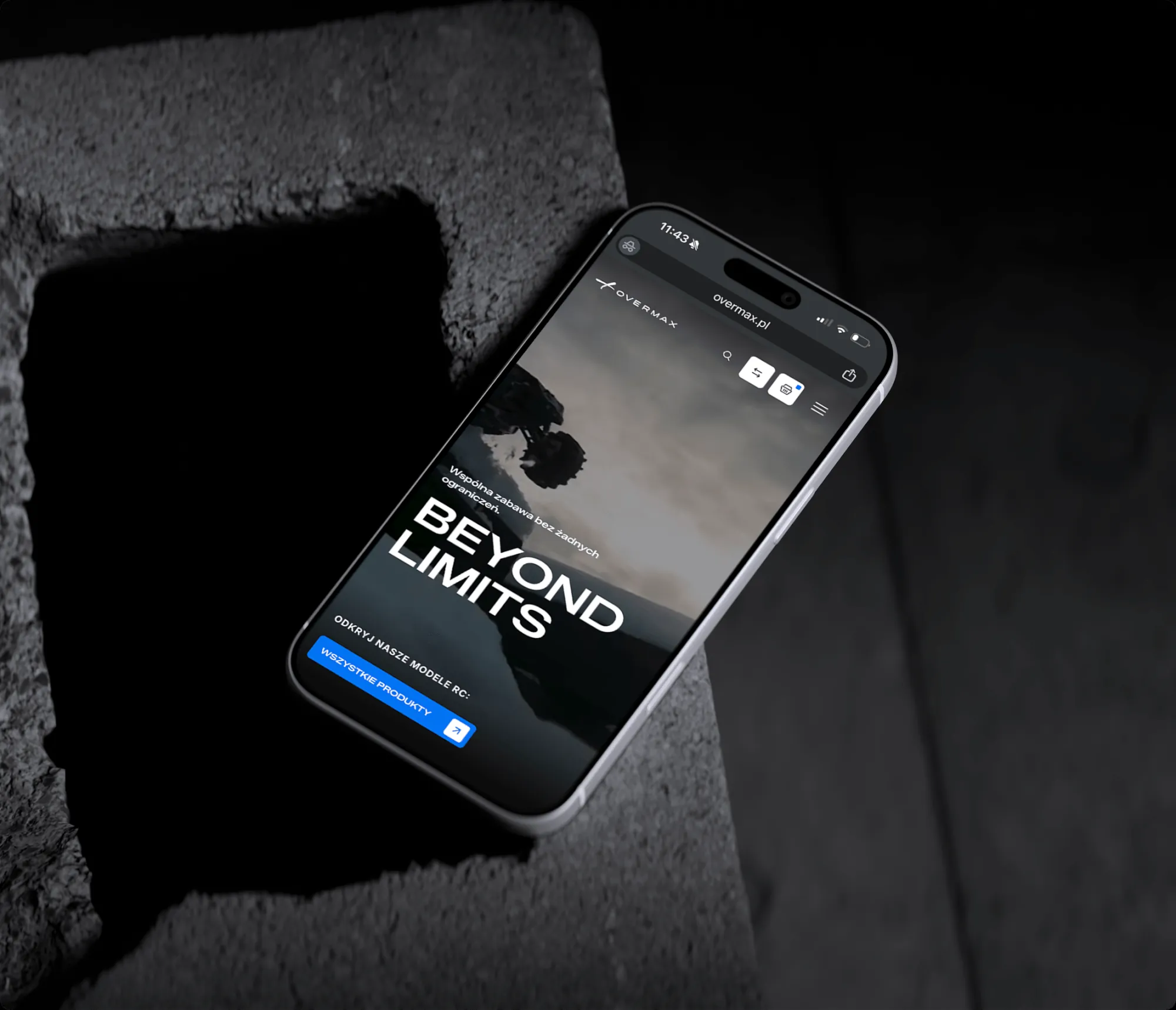 Strona główna Overmax „Beyond limits” na telefonie opartym o betonowy blok
