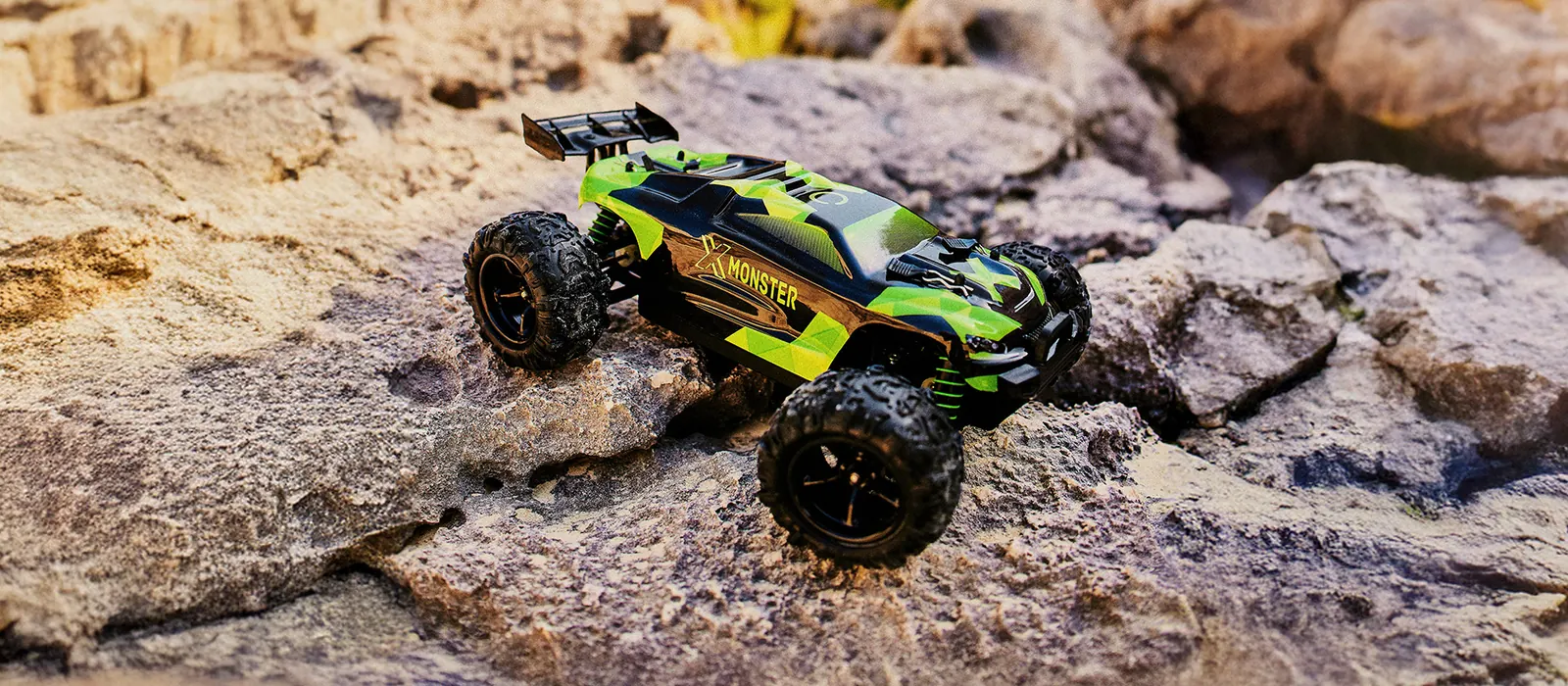 Zielony X-Monster na skałach