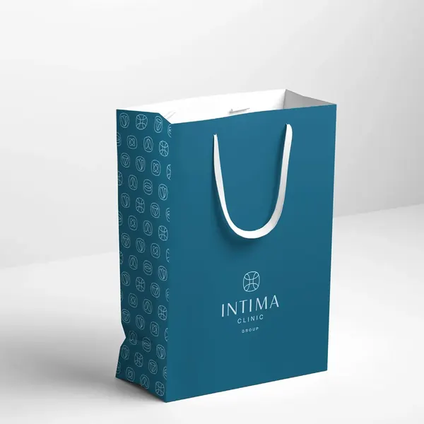 Morska papierowa torba Intima Clinic: jasny wzór ze znaków na boku i logo z przodu.