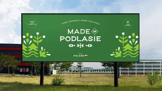 Ciemnozielony billboard Made in Podlasie z ludowymi ilustracjami.