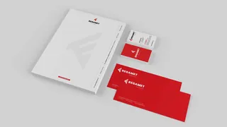 Papier firmowy, wizytówki i koperty Regamet ułożone razem.